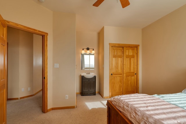 bedroom with sink, ceiling fan, ensuite bathroom, and light carpet