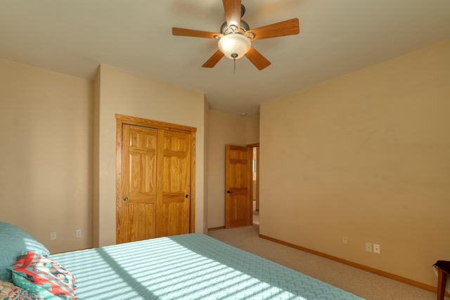 unfurnished bedroom featuring ceiling fan, light carpet, and a closet