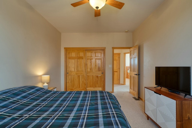 bedroom featuring light colored carpet, a closet, and ceiling fan