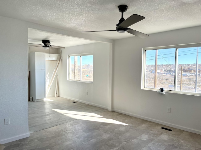 407 E Maloney Ave, Gallup, NM 87301 - spare room with a ceiling fan, healthy amount of natural light, and a textured ceiling