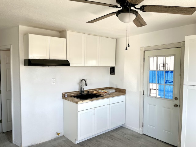407 E Maloney Ave, Gallup, NM 87301 - kitchen with a ceiling fan, white cabinetry, light wood finished floors, and under cabinet range hood