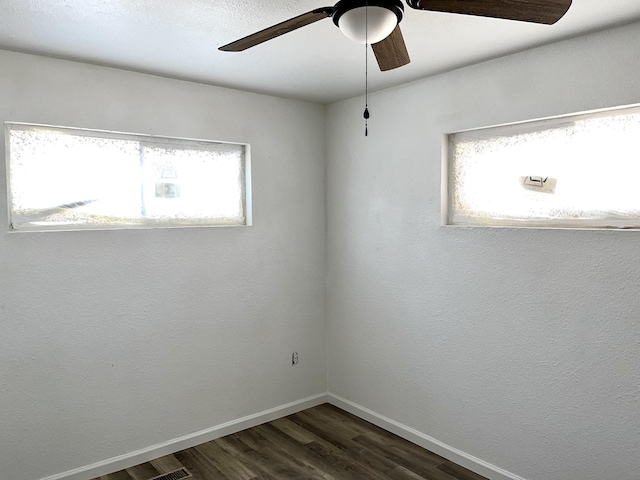 407 E Maloney Ave, Gallup, NM 87301 - empty room with ceiling fan, dark wood-type flooring, and plenty of natural light