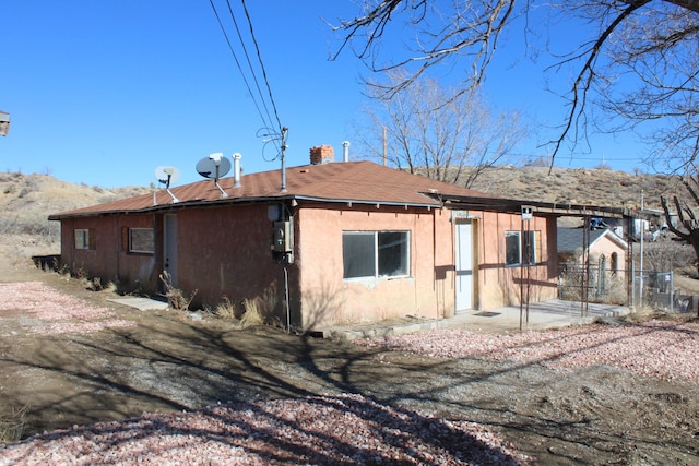 back of property featuring a patio area and a chimney