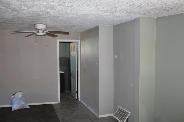 interior space featuring a textured ceiling, visible vents, and baseboards