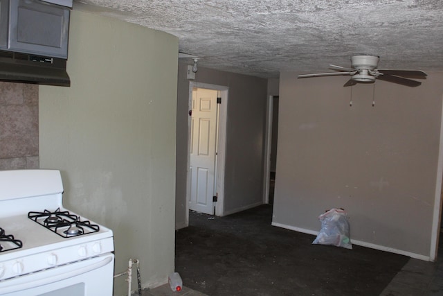 kitchen featuring a textured ceiling, under cabinet range hood, a ceiling fan, baseboards, and white range with gas cooktop