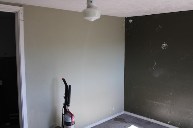 carpeted spare room featuring baseboards