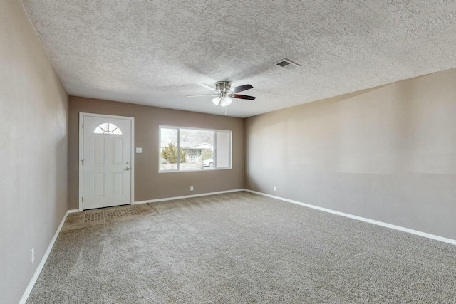 foyer with ceiling fan and carpet