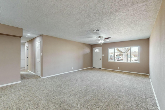 unfurnished room featuring ceiling fan, light colored carpet, and a textured ceiling