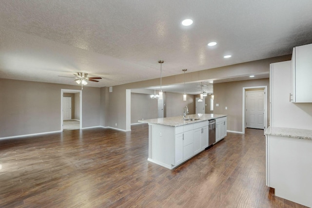 kitchen with a center island with sink, white cabinets, hanging light fixtures, and stainless steel dishwasher