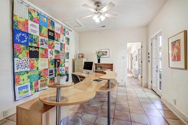 office featuring ceiling fan, light tile patterned floors, and radiator heating unit