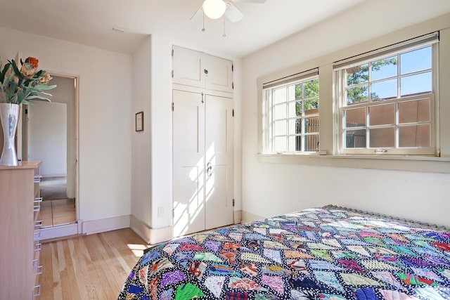 bedroom with ceiling fan, light hardwood / wood-style flooring, and a closet