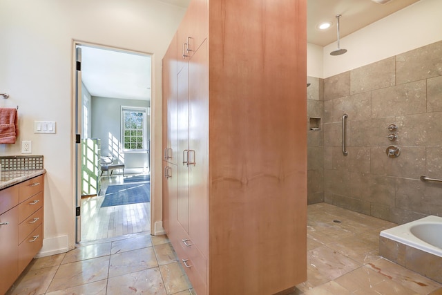 bathroom featuring a tile shower and vanity