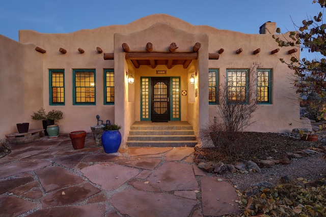 exterior entry at dusk with a patio