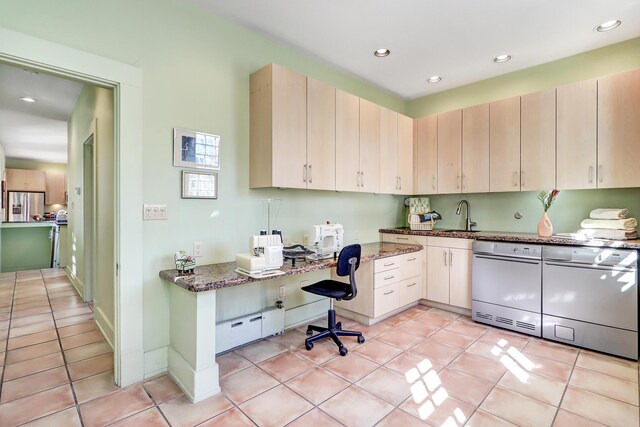 kitchen featuring light tile patterned floors, stainless steel fridge, and dark stone counters