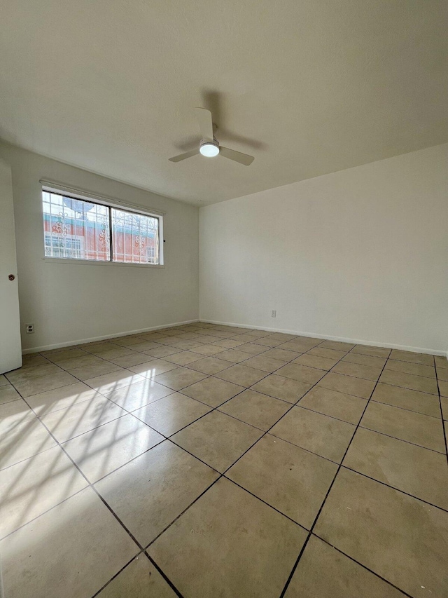 tiled spare room with ceiling fan