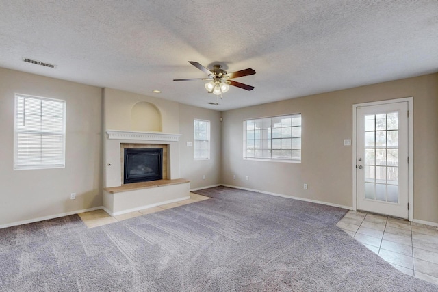 unfurnished living room with a textured ceiling, light colored carpet, and ceiling fan