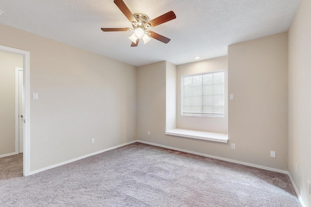 carpeted empty room featuring ceiling fan and a textured ceiling