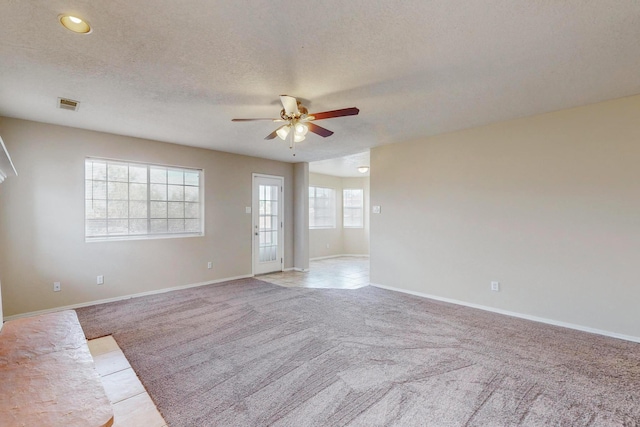 carpeted empty room with a textured ceiling and ceiling fan