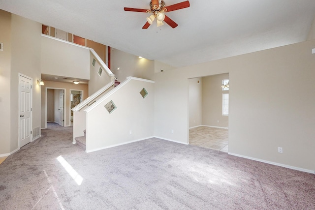 unfurnished living room featuring ceiling fan and light colored carpet