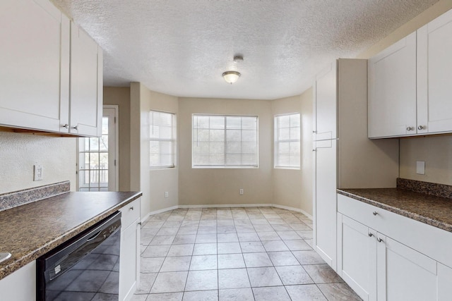 kitchen with dishwasher, white cabinets, dark stone countertops, light tile patterned floors, and a textured ceiling