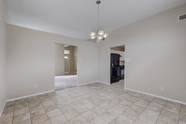 spare room featuring a notable chandelier