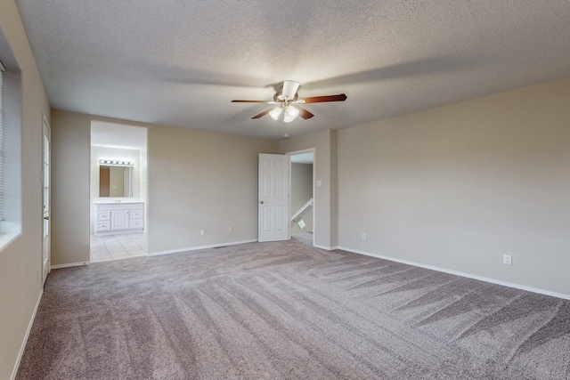 carpeted spare room featuring ceiling fan and a textured ceiling