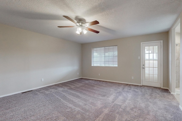 carpeted empty room featuring a textured ceiling and ceiling fan