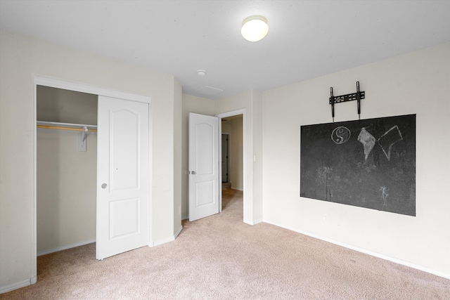 unfurnished bedroom featuring light carpet and a closet