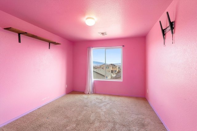 spare room featuring a textured ceiling and carpet floors