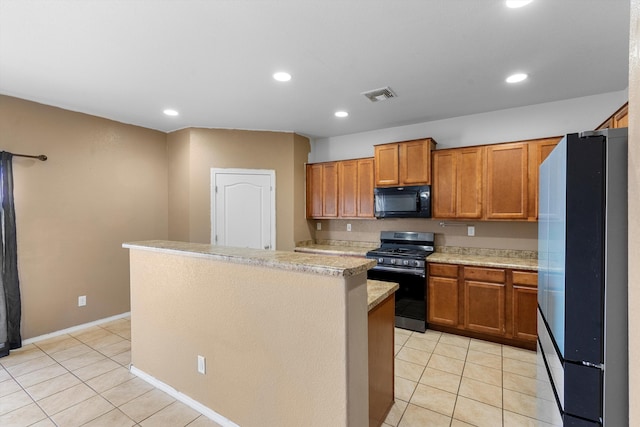 kitchen featuring light tile patterned floors, refrigerator, gas stove, and a kitchen island