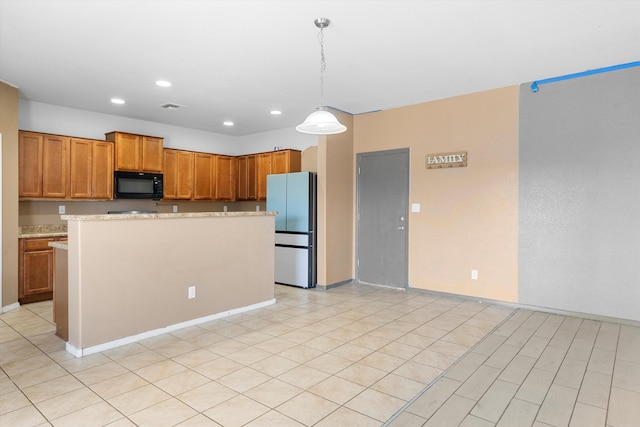 kitchen with decorative light fixtures, a center island, fridge, and light stone counters