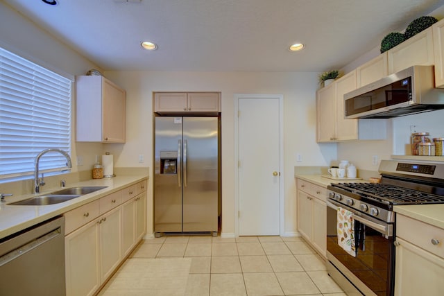 kitchen with sink, light tile patterned floors, and stainless steel appliances