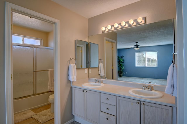 full bathroom featuring vanity, a healthy amount of sunlight, ceiling fan, and shower / bath combination with glass door