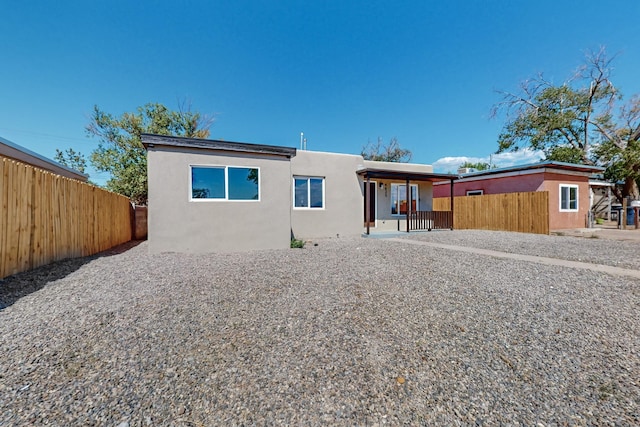 back of property featuring covered porch