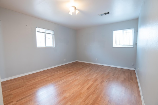 empty room with light hardwood / wood-style floors and a wealth of natural light