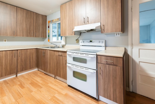 kitchen featuring electric range, light hardwood / wood-style flooring, and sink