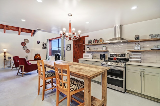 kitchen featuring tasteful backsplash, wall chimney exhaust hood, stainless steel range, pendant lighting, and beamed ceiling