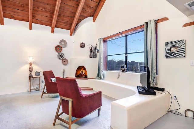 living area with lofted ceiling with beams and wood ceiling