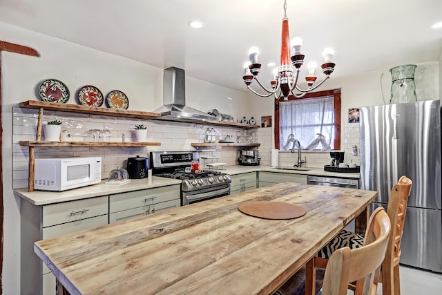 kitchen with open shelves, decorative backsplash, appliances with stainless steel finishes, wall chimney exhaust hood, and a sink