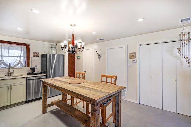 dining space with sink and a chandelier