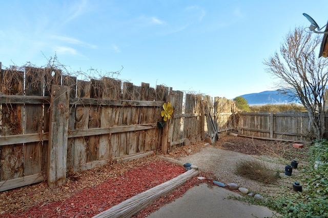 view of yard with a fenced backyard and a mountain view