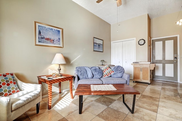 living room featuring ceiling fan, a textured ceiling, and high vaulted ceiling