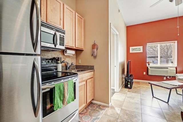 kitchen with stainless steel appliances, tasteful backsplash, light brown cabinetry, sink, and light tile patterned flooring