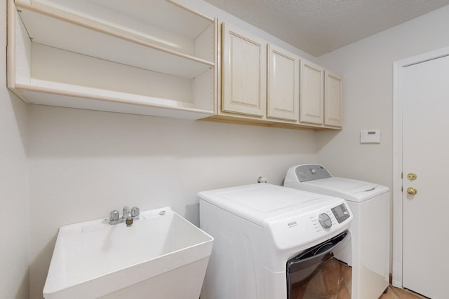 washroom with cabinets, separate washer and dryer, and sink