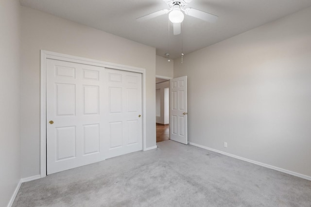 unfurnished bedroom with ceiling fan, a closet, and light carpet