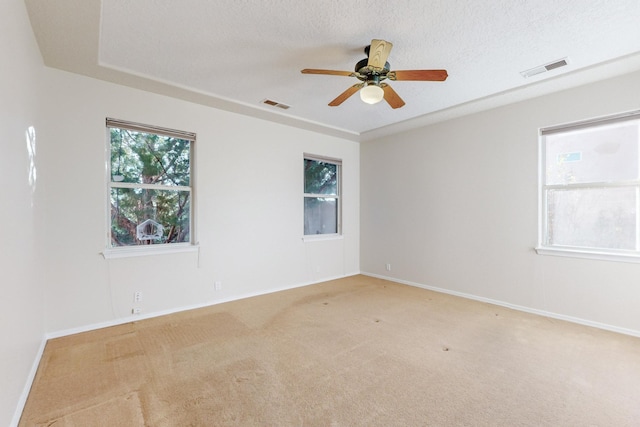 carpeted empty room with ceiling fan and a textured ceiling