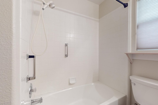 bathroom featuring bathtub / shower combination and toilet