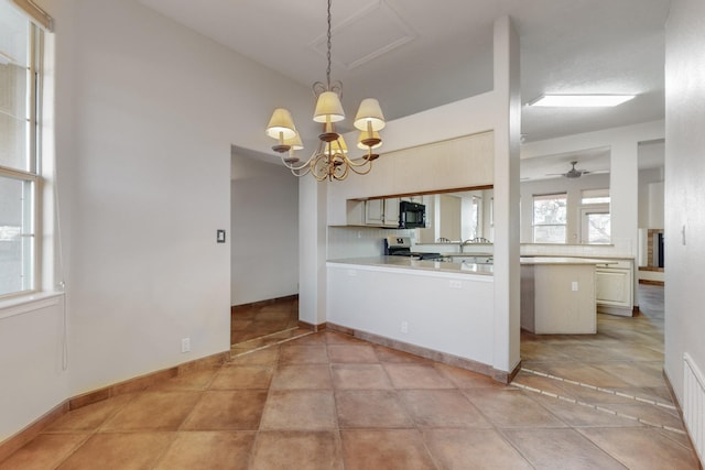 kitchen featuring backsplash, kitchen peninsula, pendant lighting, stainless steel stove, and ceiling fan with notable chandelier