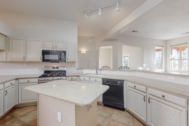 kitchen with sink, a center island, light stone counters, backsplash, and black appliances