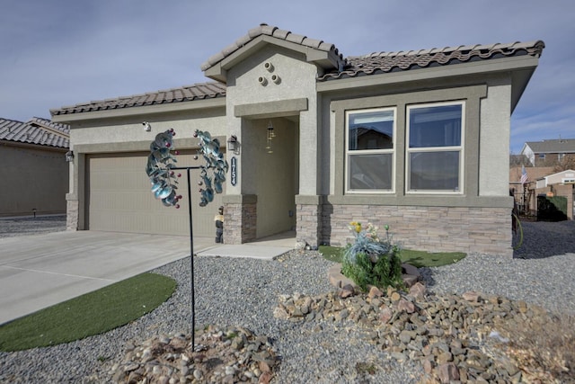 mediterranean / spanish-style house featuring stucco siding, driveway, stone siding, an attached garage, and a tiled roof